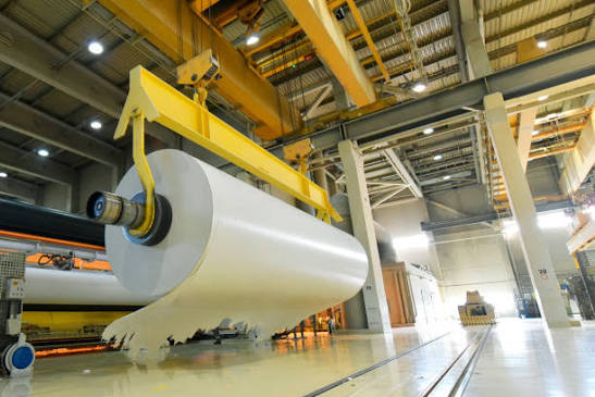 Large paper roll being handled in a modern warehouse
